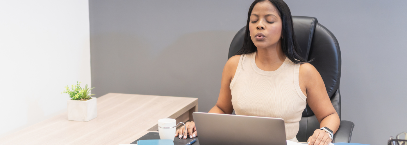 Employee practicing mindfulness techniques to stop negative thoughts at work Employee practicing mindfulness techniques to stop negative thoughts at work