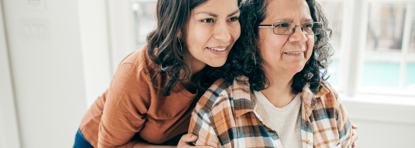 Blog header image showing an employed family caregiver assisting a loved one at home 