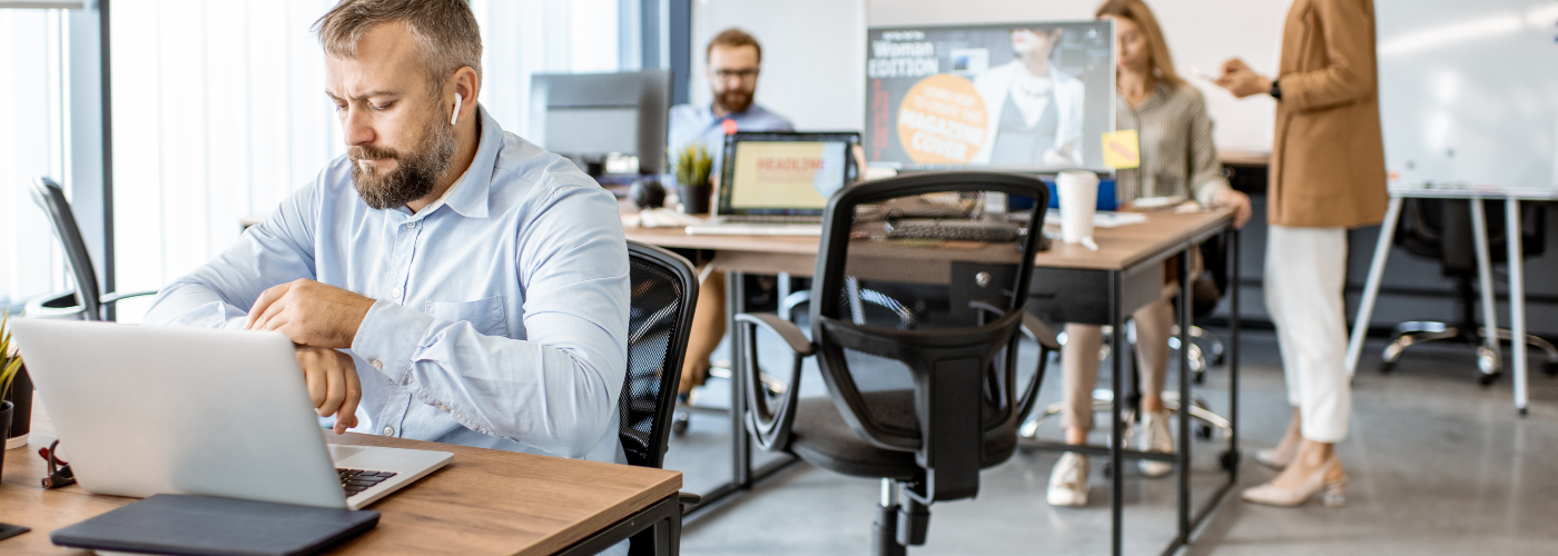 Lonely Man in the workplace working by himself with earbuds in Lonely Man in the workplace working by himself with earbuds in